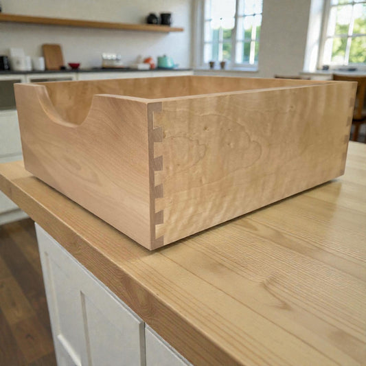Wooden bread box on a kitchen counter with a blurred background
