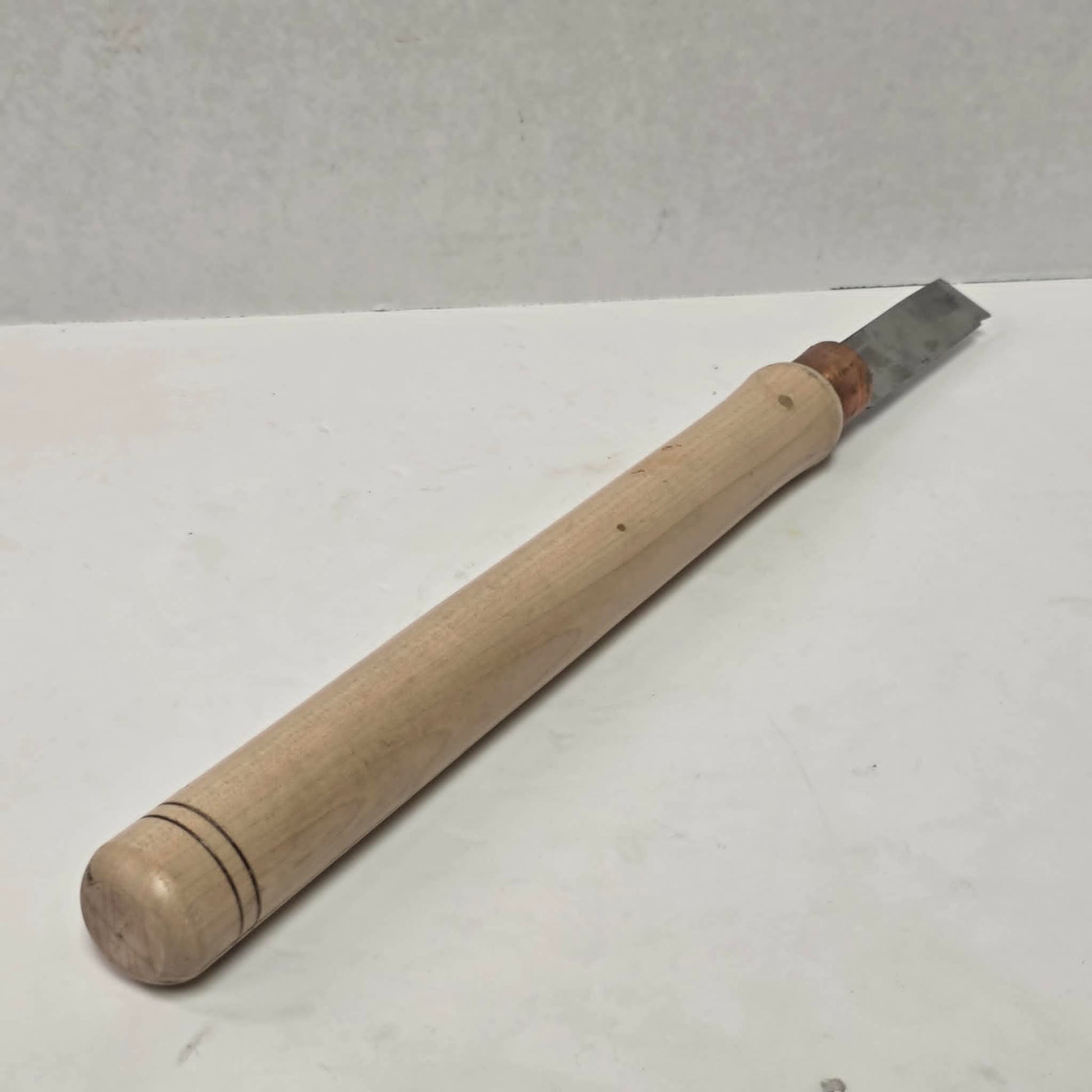 Custom-made thin woodturning parting chisel for precision detail work on a wood lathe.