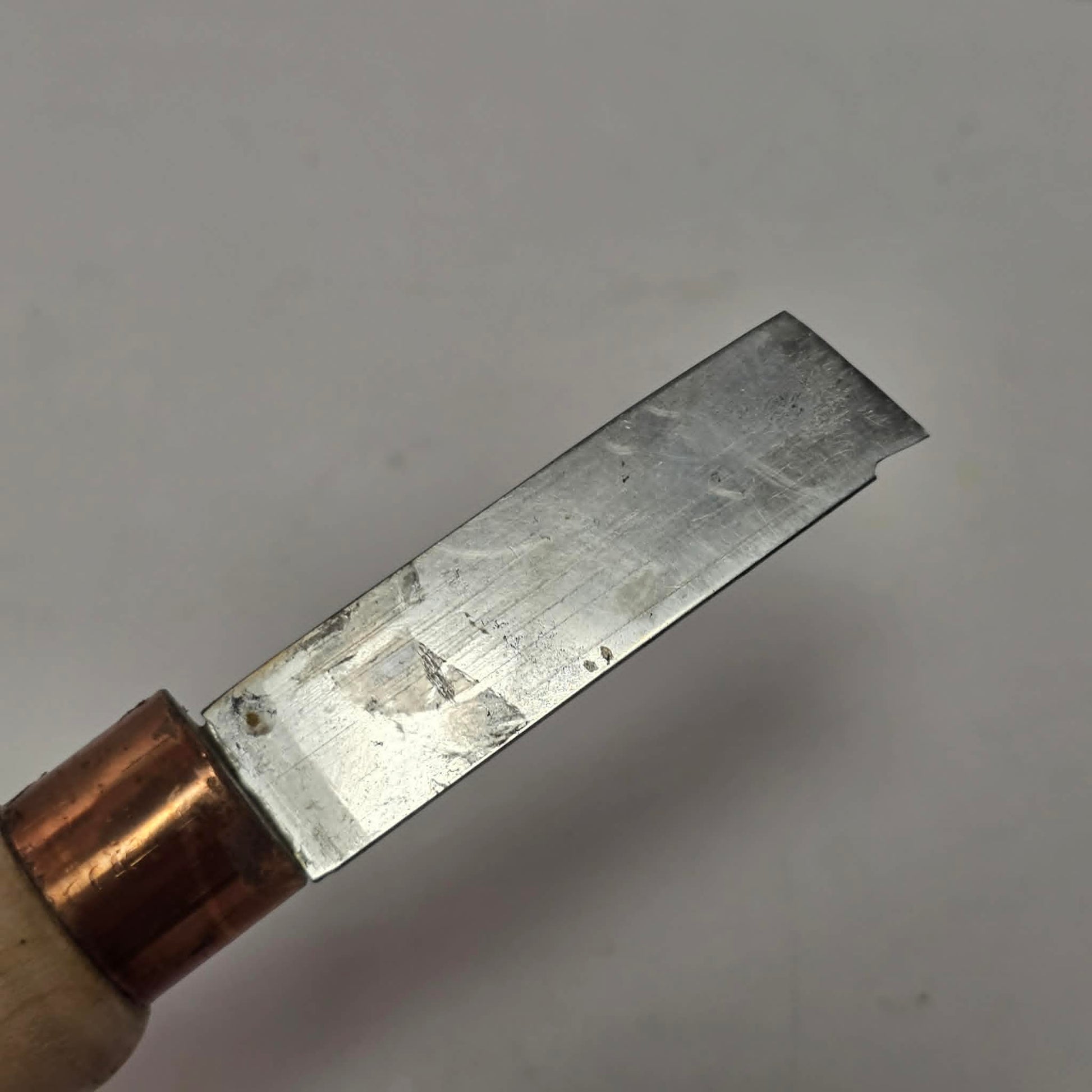 Custom-made thin woodturning parting chisel for precision detail work on a wood lathe.