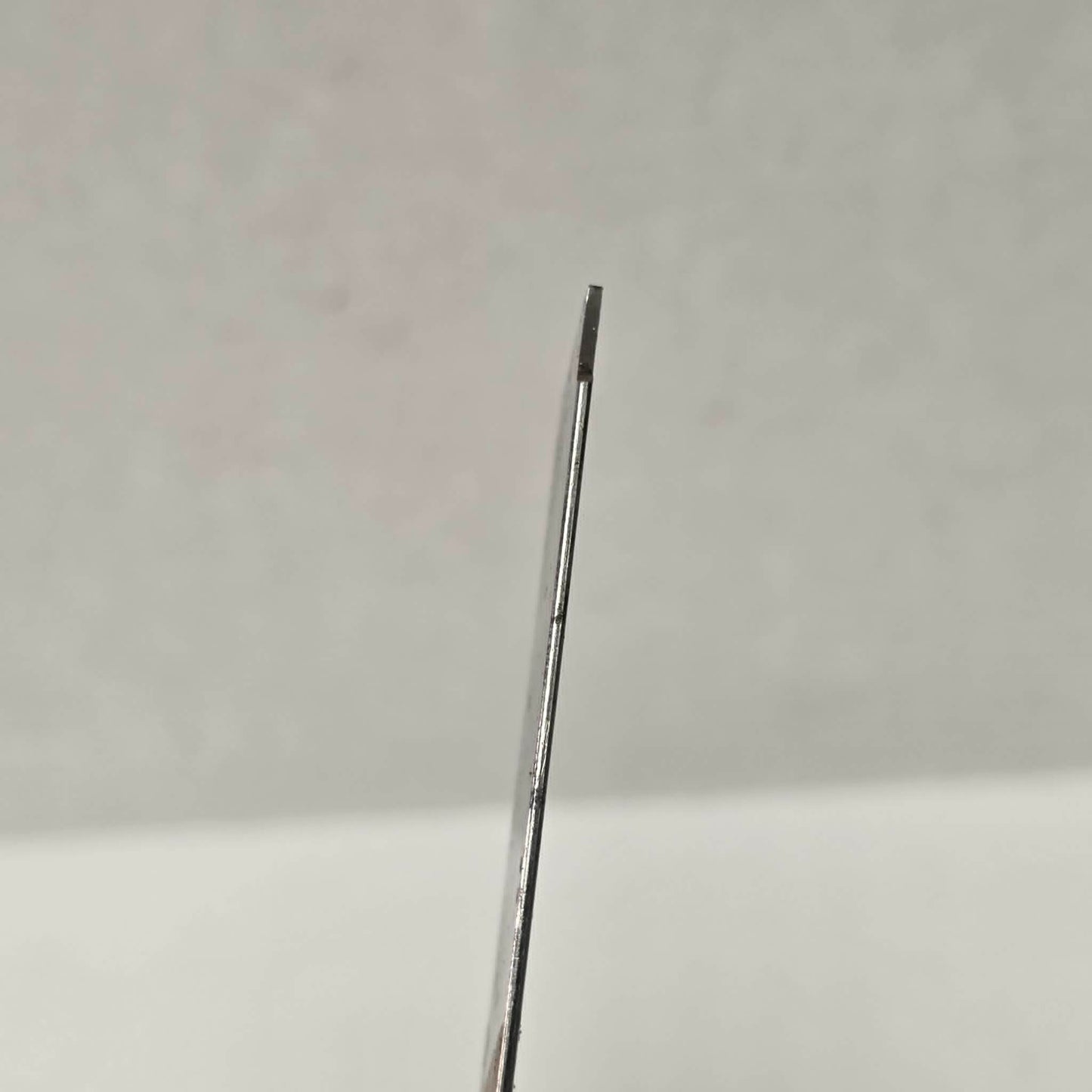 Custom-made thin woodturning parting chisel for precision detail work on a wood lathe.