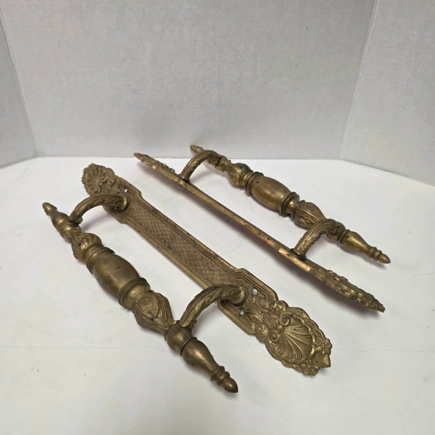 Pair of large Victorian brass bronze hotel door handles with butterfly design, crosshatched plates, and shell details. Antique architectural salvage hardware.