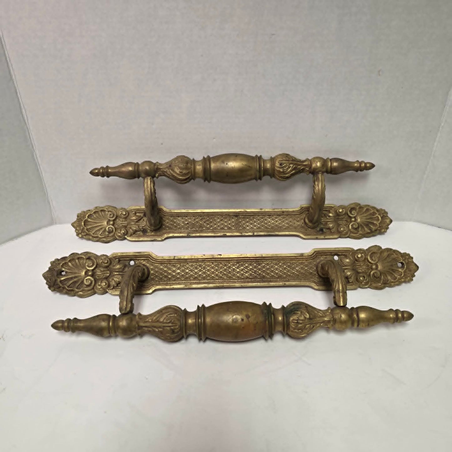 Pair of large Victorian brass bronze hotel door handles with butterfly design, crosshatched plates, and shell details. Antique architectural salvage hardware.