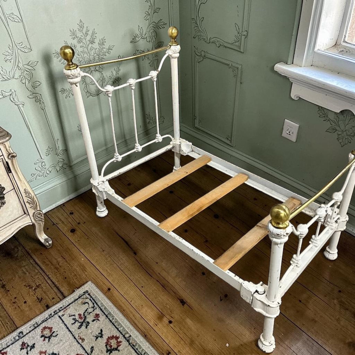 A charming Victorian iron and brass miniature bed from a bygone era.