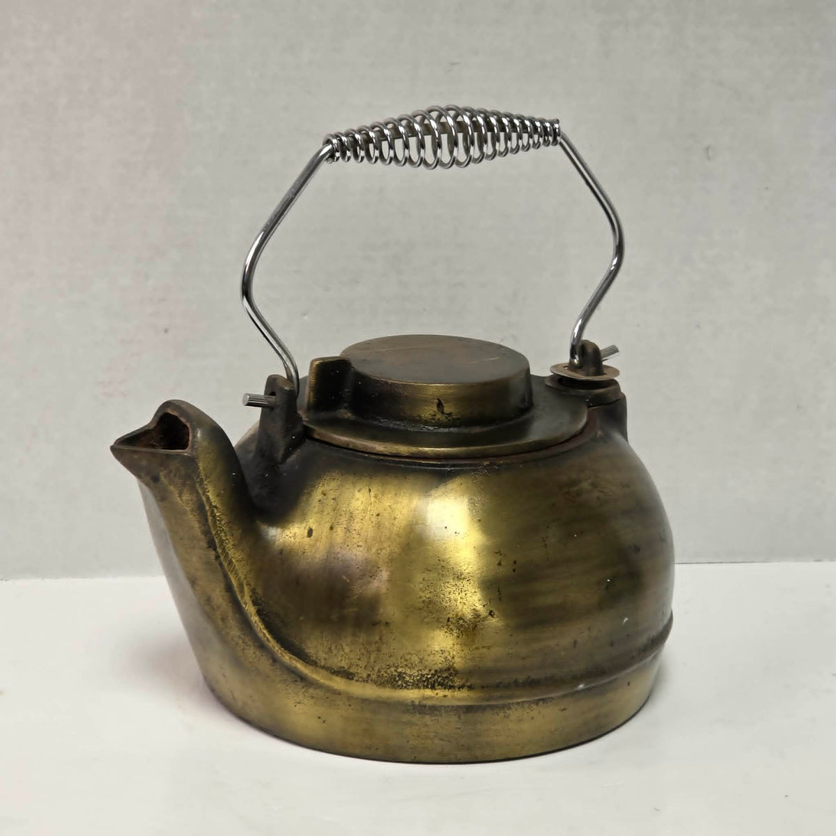 Vintage brass plated cast iron kettle with attached swivel lid for wood stove use.
