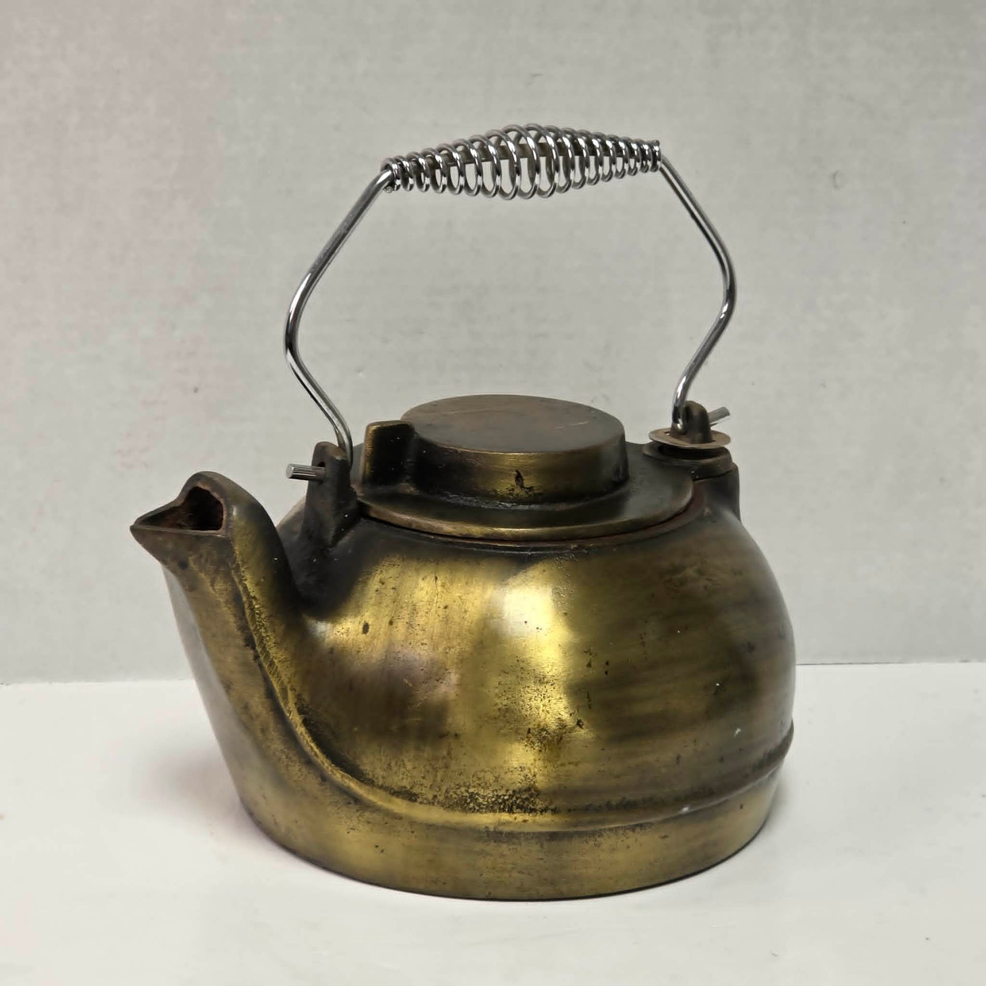 Vintage brass plated cast iron kettle with attached swivel lid for wood stove use.
