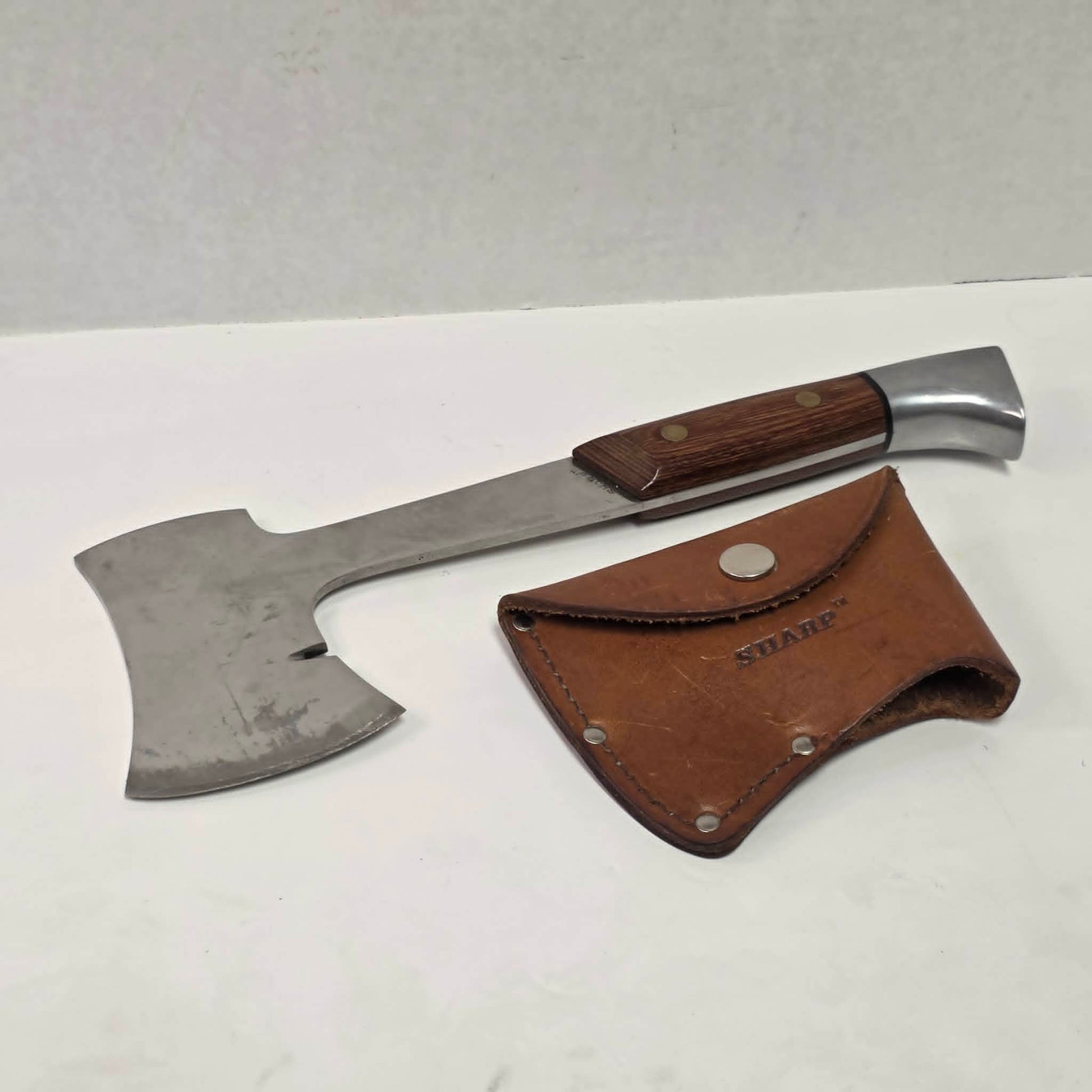 A beautifully crafted vintage camping axe featuring a rosewood handle, sharp stainless steel blade, and quality leather sheath.
