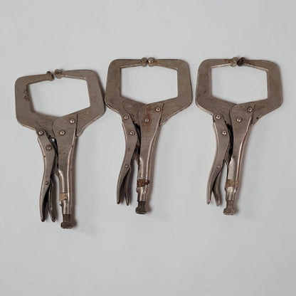 Set of three 11 inch C-clamp locking pliers used for welding and metal fabrication in a workshop setting.