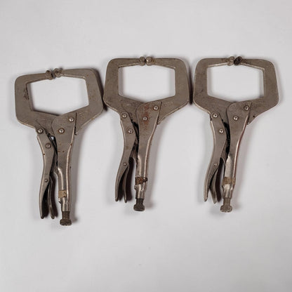 Set of three 11 inch C-clamp locking pliers used for welding and metal fabrication in a workshop setting.