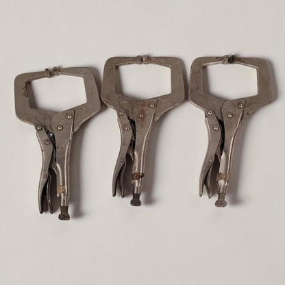 Set of three 11 inch C-clamp locking pliers used for welding and metal fabrication in a workshop setting.