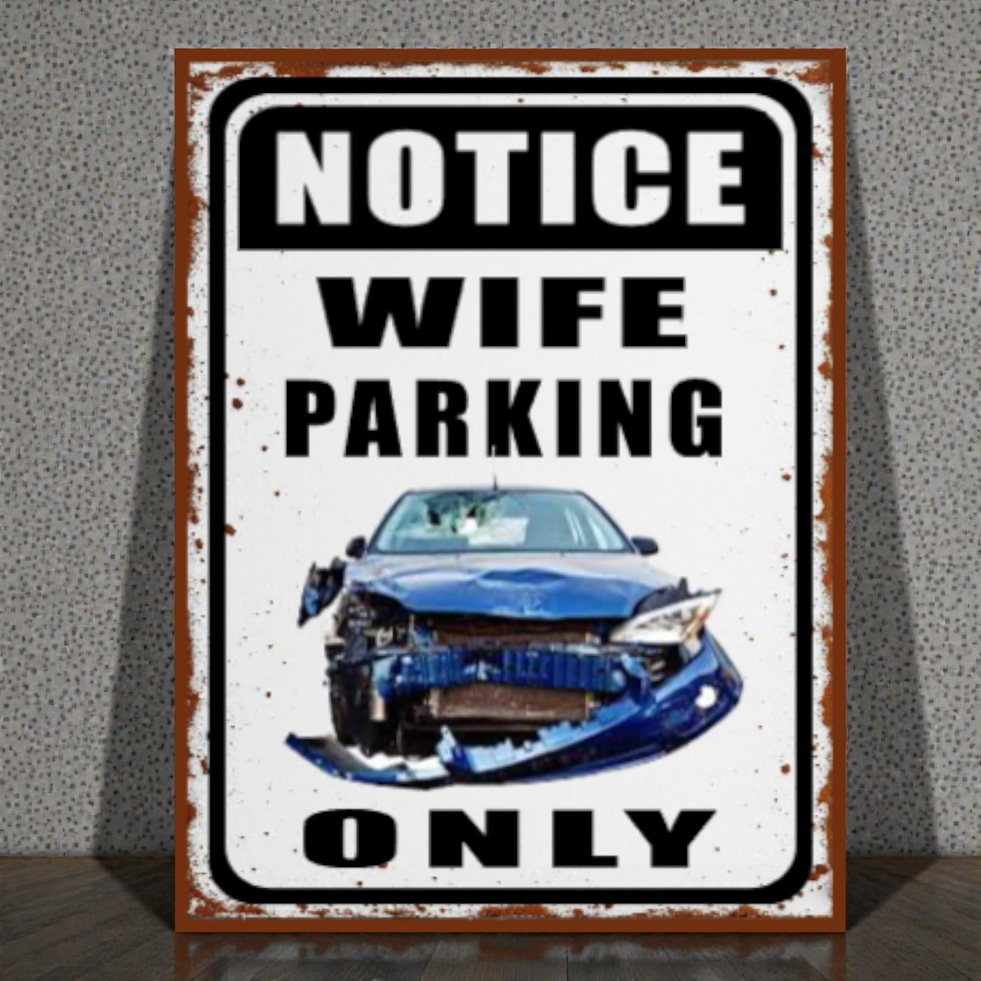 Metal sign with a blue car and text 'Notice Wife Parking Only' on a textured wall background