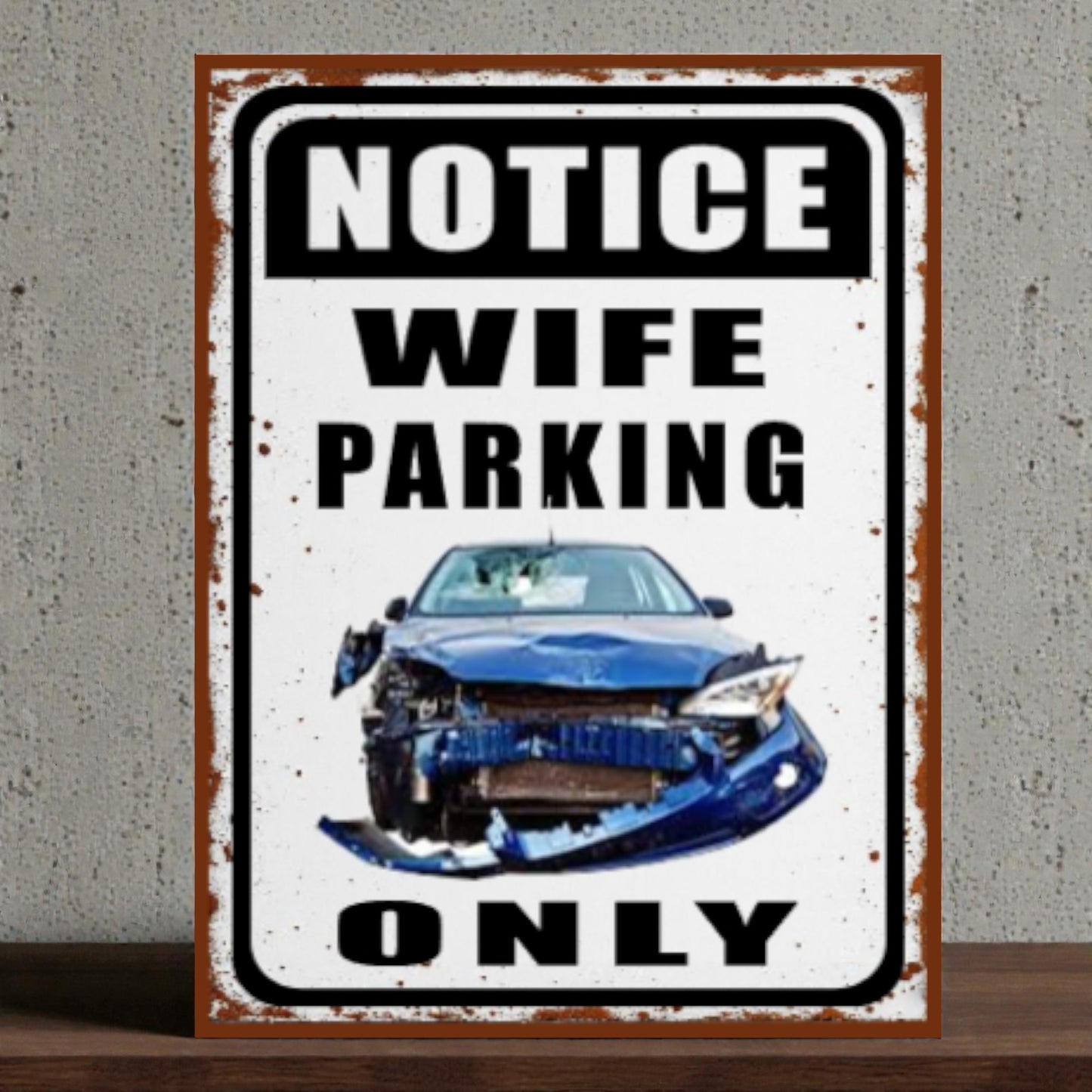 Metal sign with a car and text 'Notice Wife Parking Only' on a textured wall background