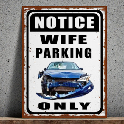 Metal sign with a car illustration and text 'Notice Wife Parking Only' on a gray background.