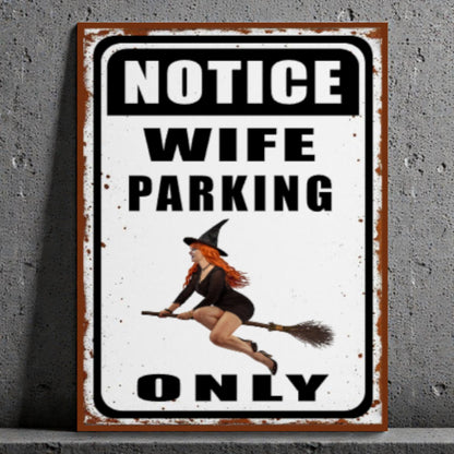 Metal sign with a witch design and text 'Notice Wife Parking Only' on a gray background