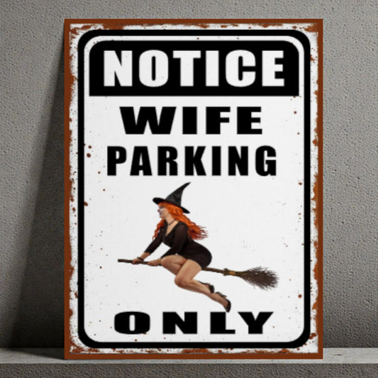 Metal sign with a witch design and text 'Notice Wife Parking Only' on a gray background