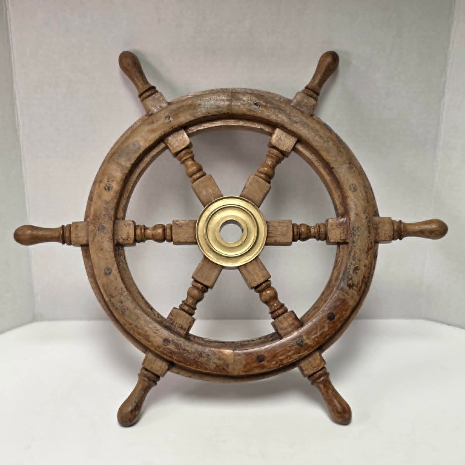 Authentic vintage wood and brass ship's wheel with beautiful original maritime patina.