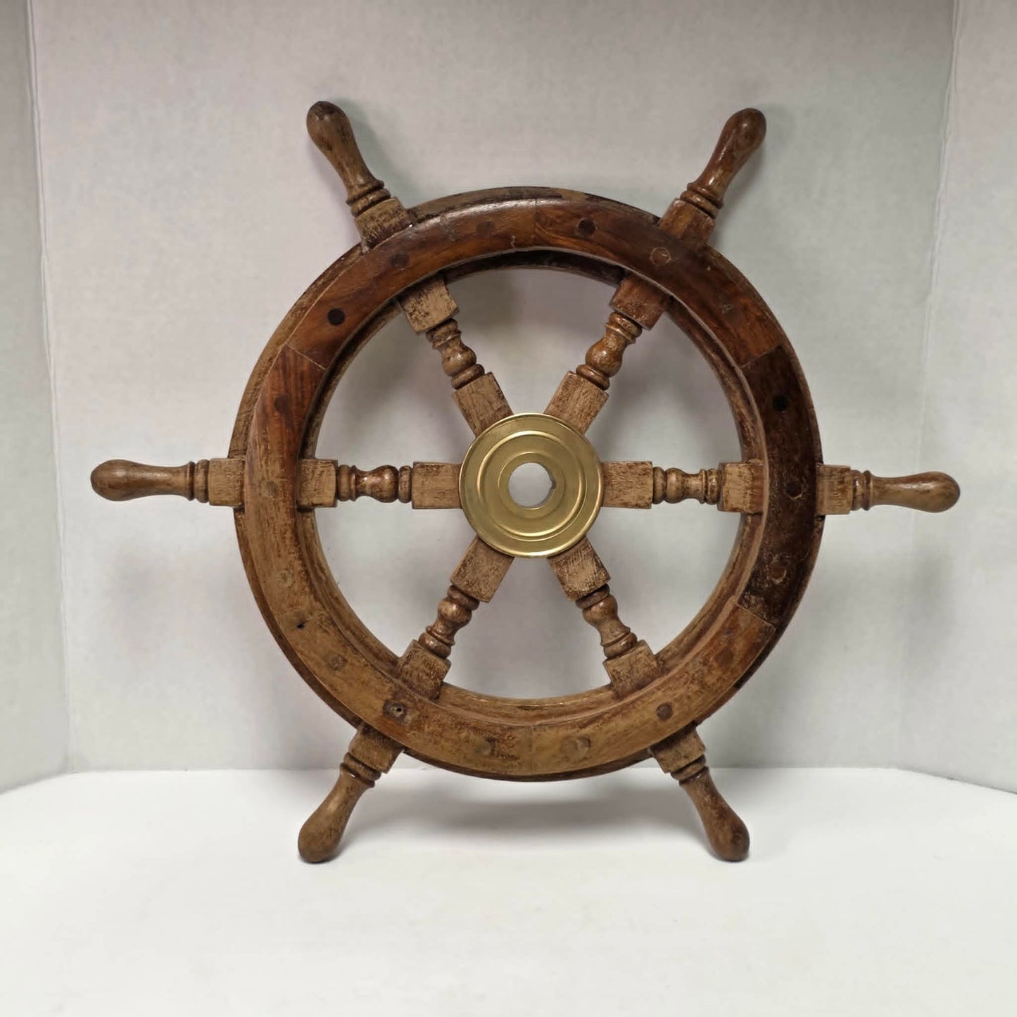 Authentic vintage wood and brass ship's wheel with beautiful original maritime patina.