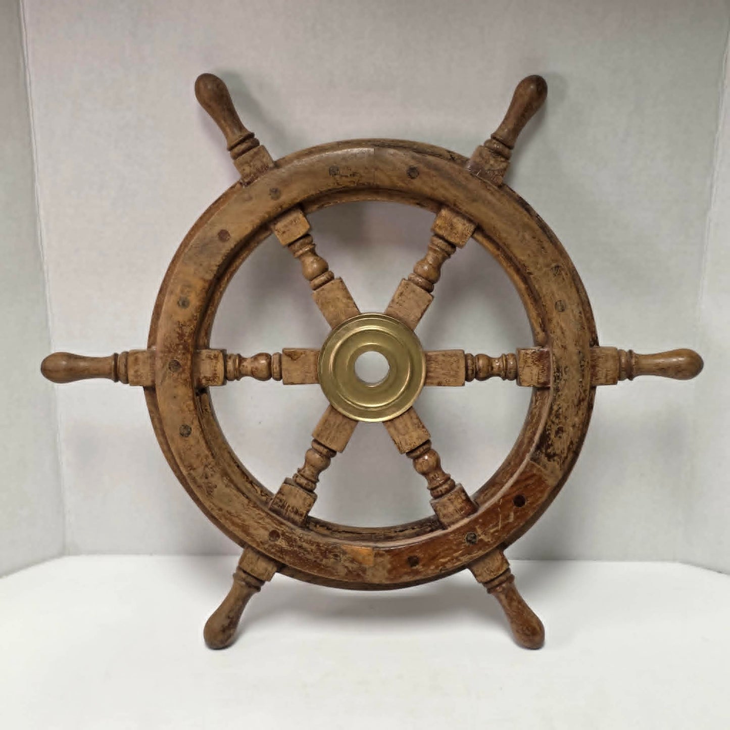 Authentic vintage wood and brass ship's wheel with beautiful original maritime patina.