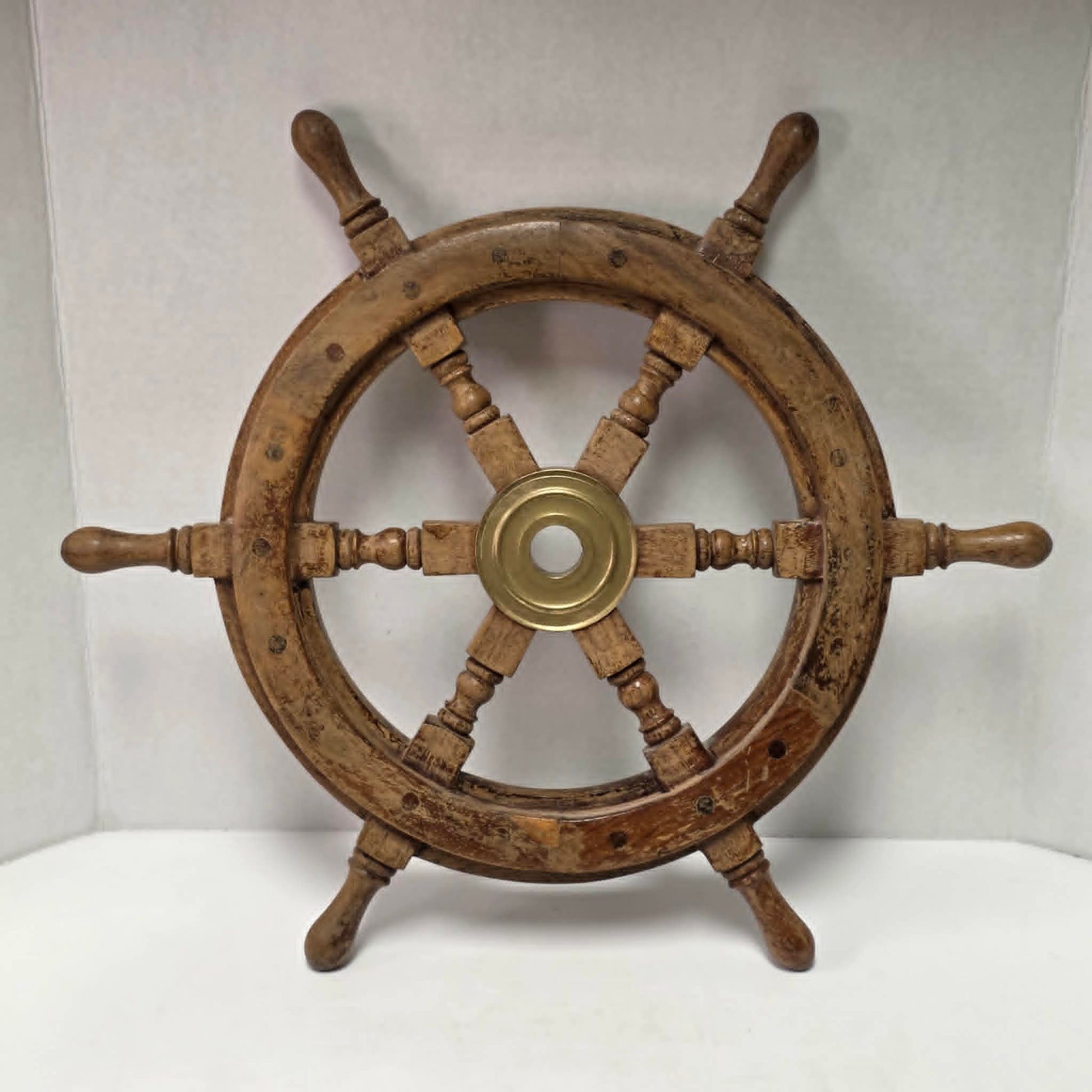 Authentic vintage wood and brass ship's wheel with beautiful original maritime patina.