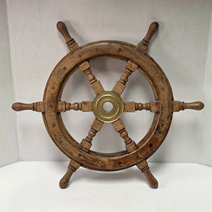 Authentic vintage wood and brass ship's wheel with beautiful original maritime patina.