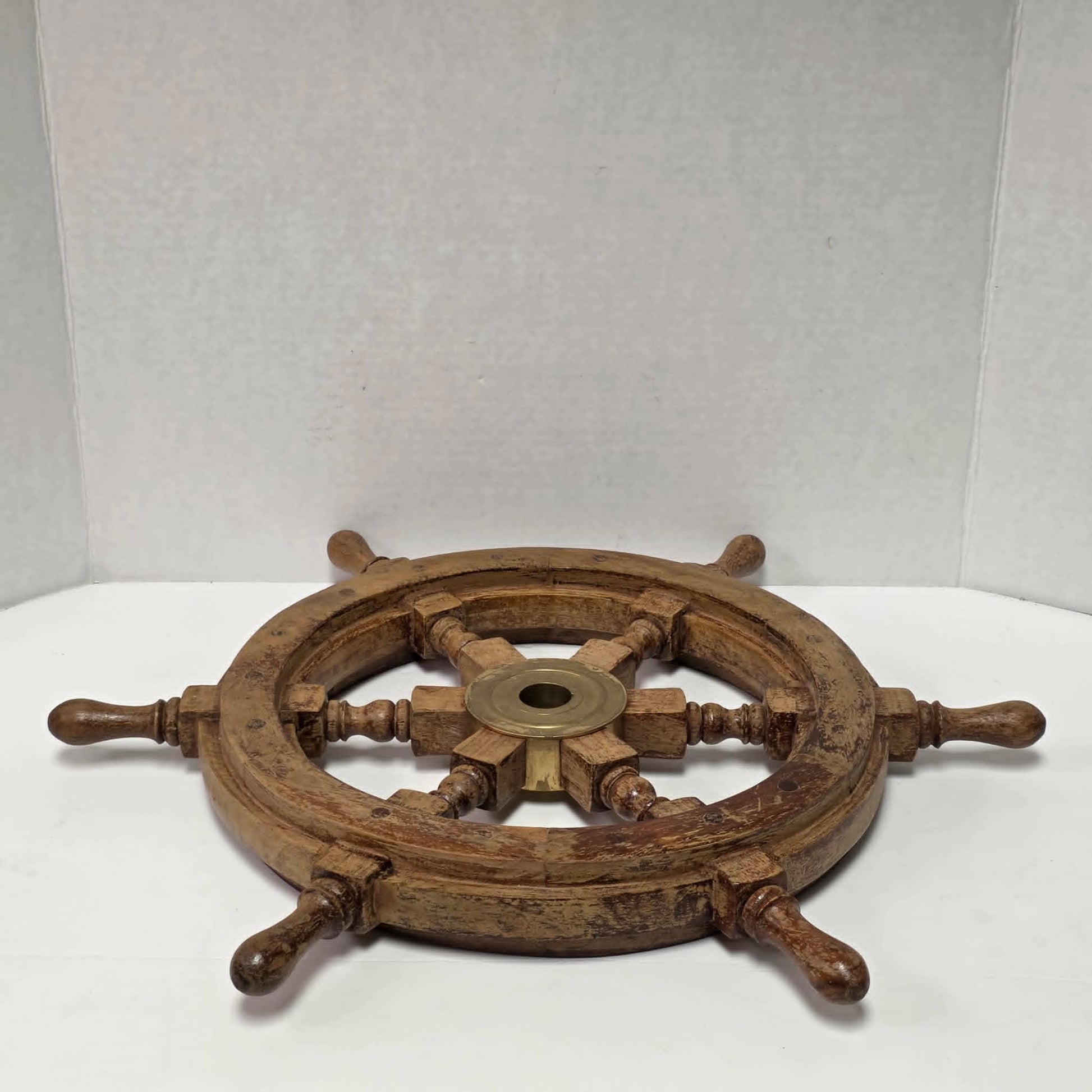 Authentic vintage wood and brass ship's wheel with beautiful original maritime patina.