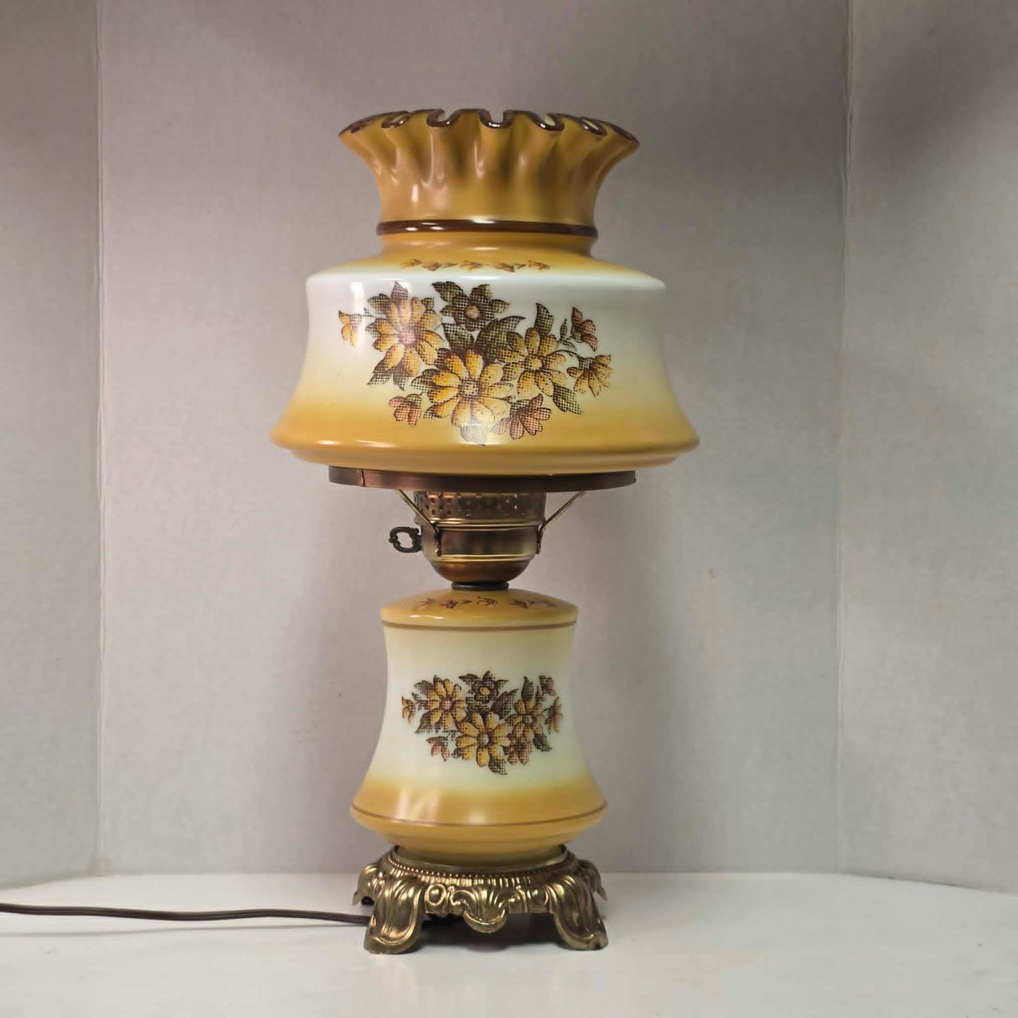 Vintage harvest gold hurricane lamp with needlepoint floral shade and font featuring tri-light operation.