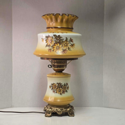 Vintage harvest gold hurricane lamp with needlepoint floral shade and font featuring tri-light operation.