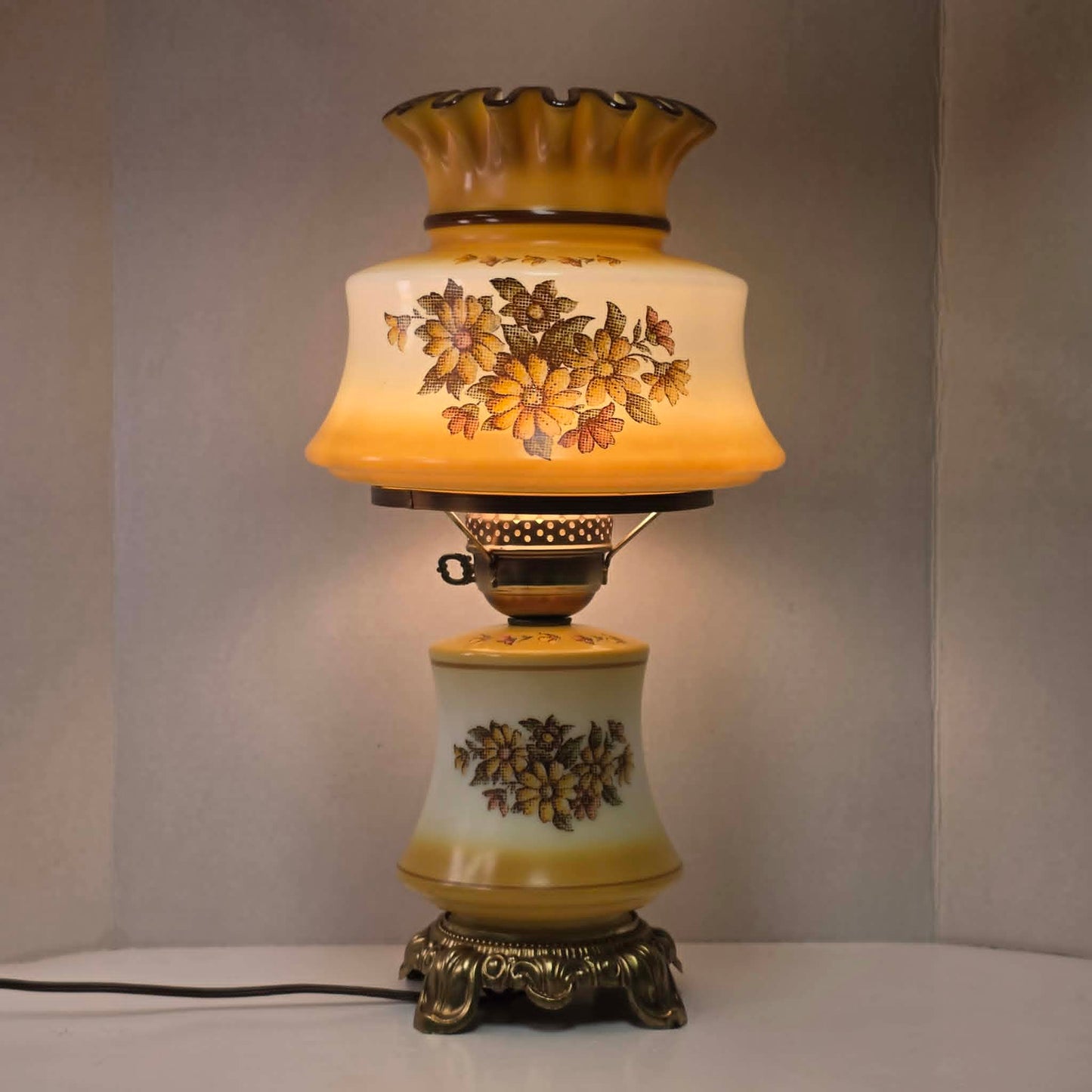 Vintage harvest gold hurricane lamp with needlepoint floral shade and font featuring tri-light operation.