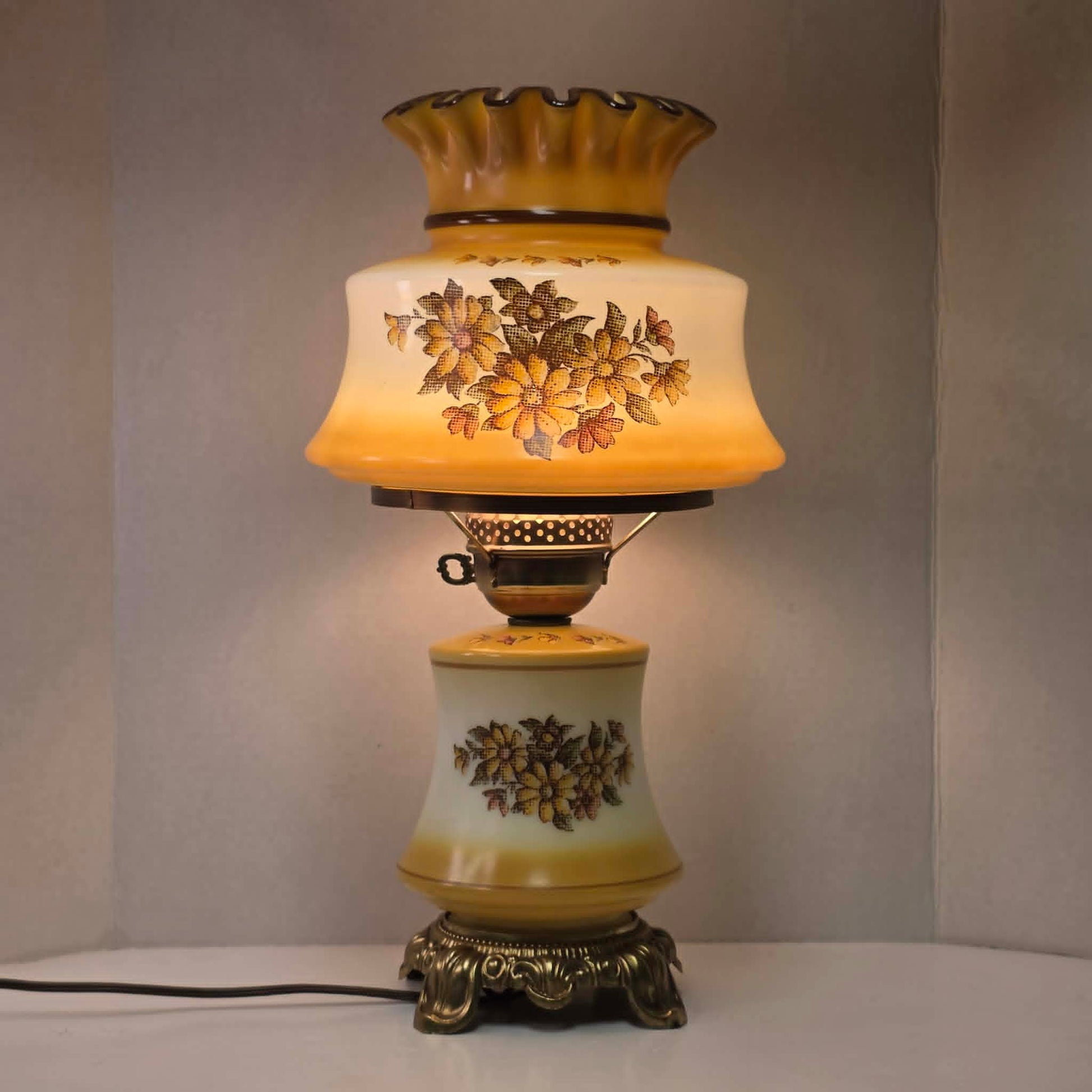 Vintage harvest gold hurricane lamp with needlepoint floral shade and font featuring tri-light operation.