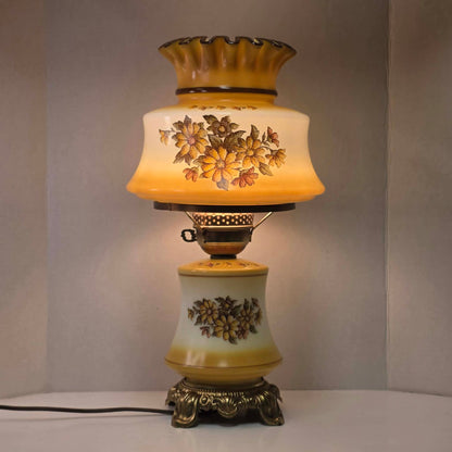 Vintage harvest gold hurricane lamp with needlepoint floral shade and font featuring tri-light operation.