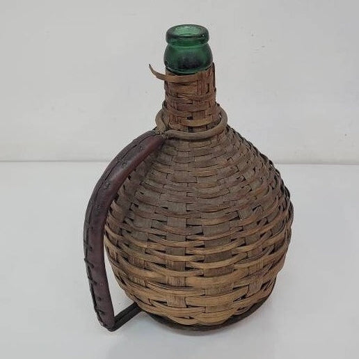 green glass wine bottle with wicker basket oudepont italy