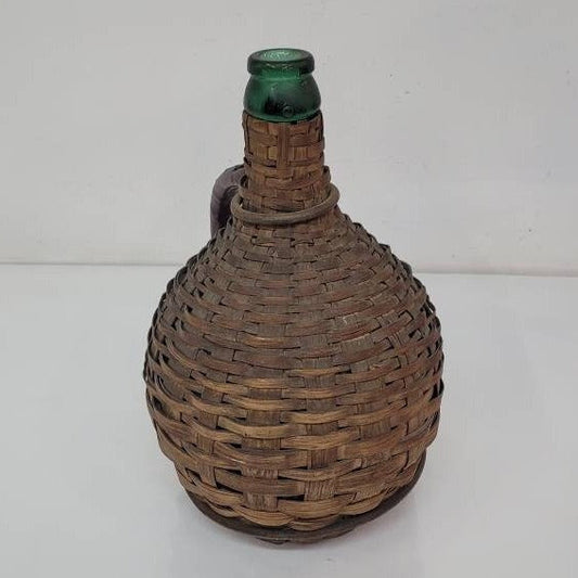 green glass wine bottle with wicker basket oudepont italy