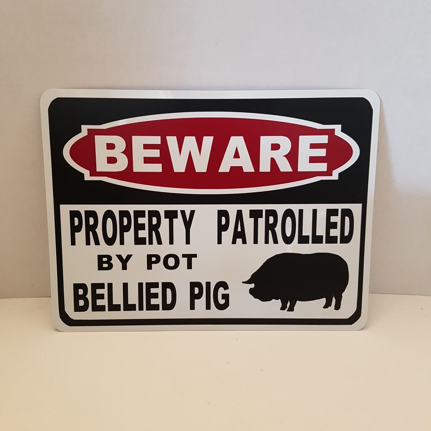 beware sign property patrolled by pot bellied pig