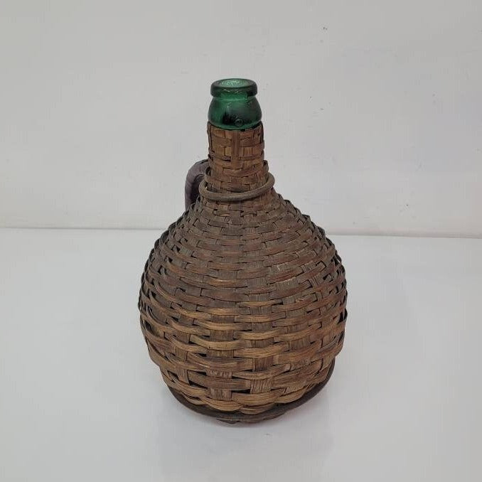 green glass wine bottle with wicker basket oudepont italy