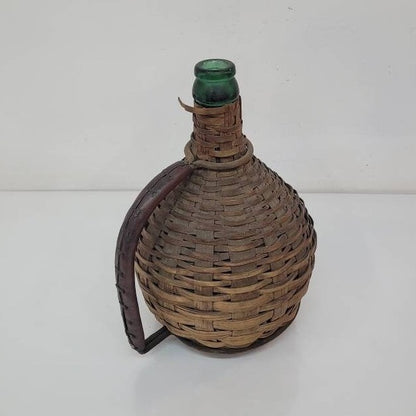 green glass wine bottle with wicker basket oudepont italy